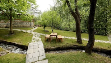 A garden with a stone pathway, a wooden table, and a bench.