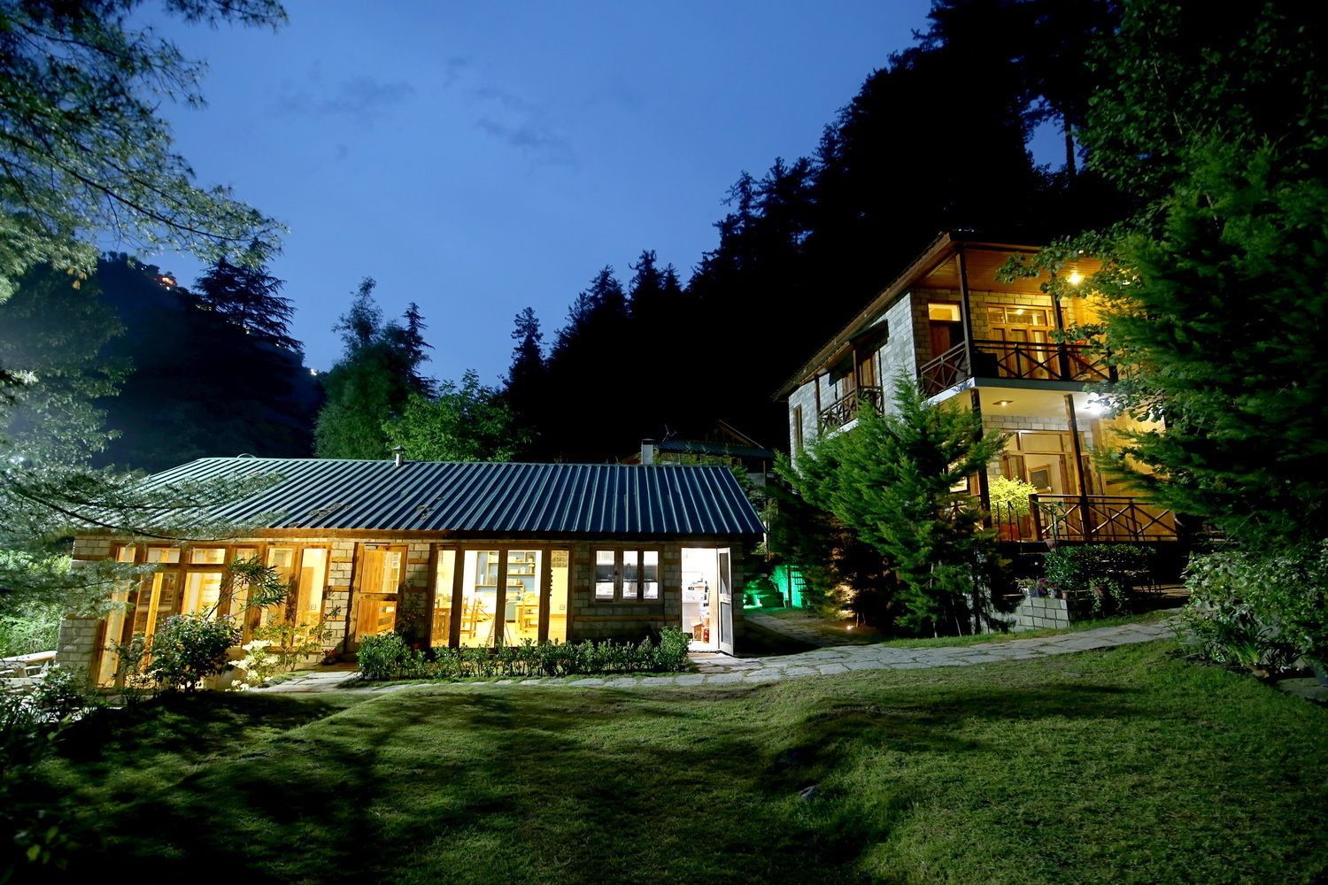 A two-story building with a balcony and a separate structure with a sloped roof.