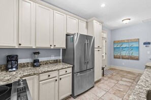A kitchen with white cabinets, a stainless steel refrigerator, a coffee maker, and a blender. - Luxury 3BR 2.5BA Townhome w/Resort Perks (North Myrtle Beach)