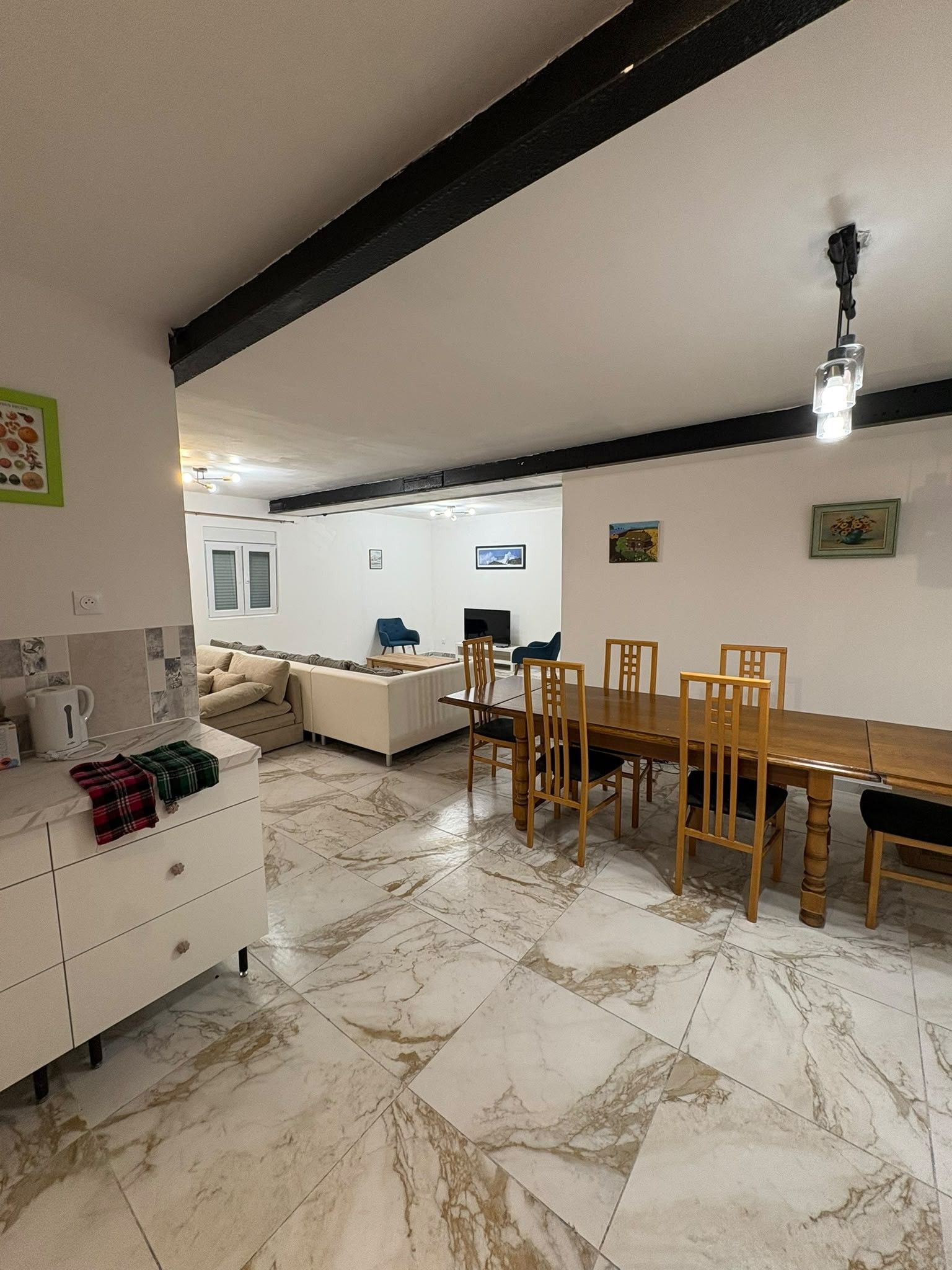 Een moderne woonruimte met een eethoek, keuken en zithoek.