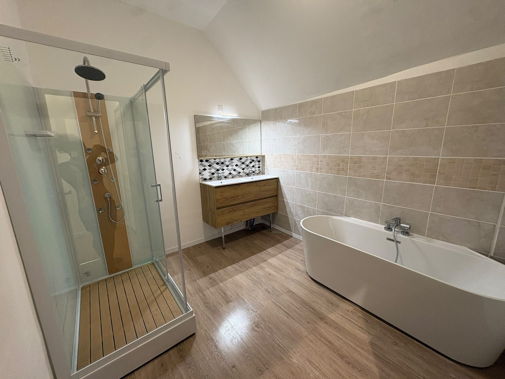 Une salle de bain moderne avec une douche à parois de verre, une baignoire sur pieds et un meuble-lavabo en bois.