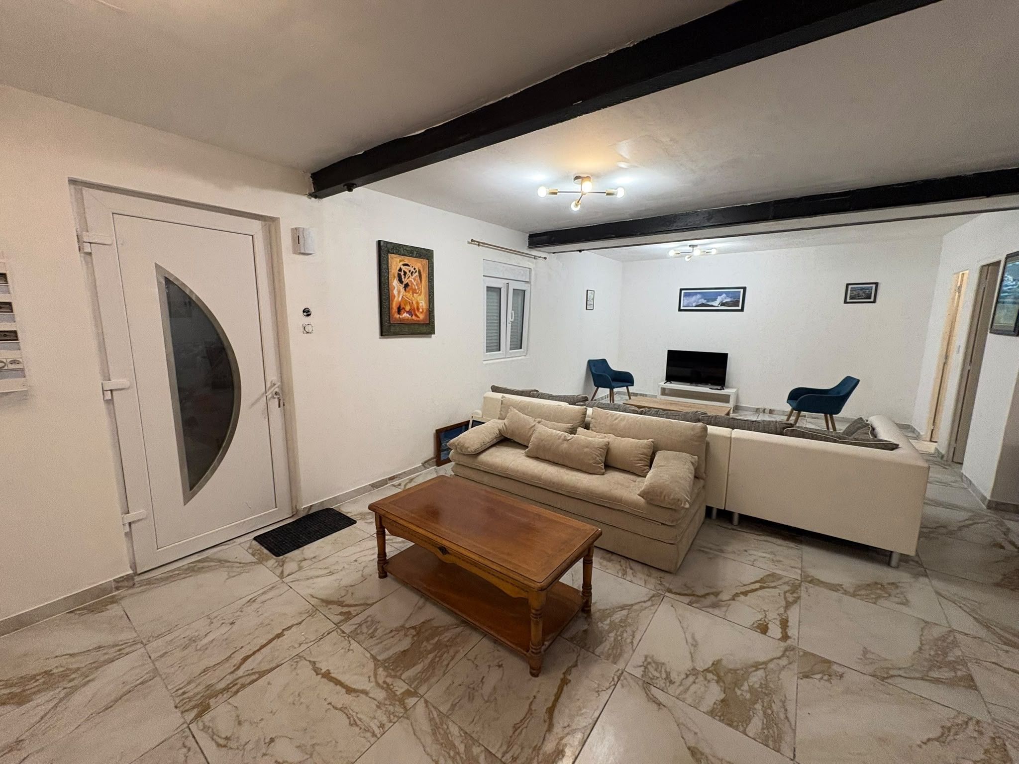 A living room with a sofa, coffee table, and a television.
