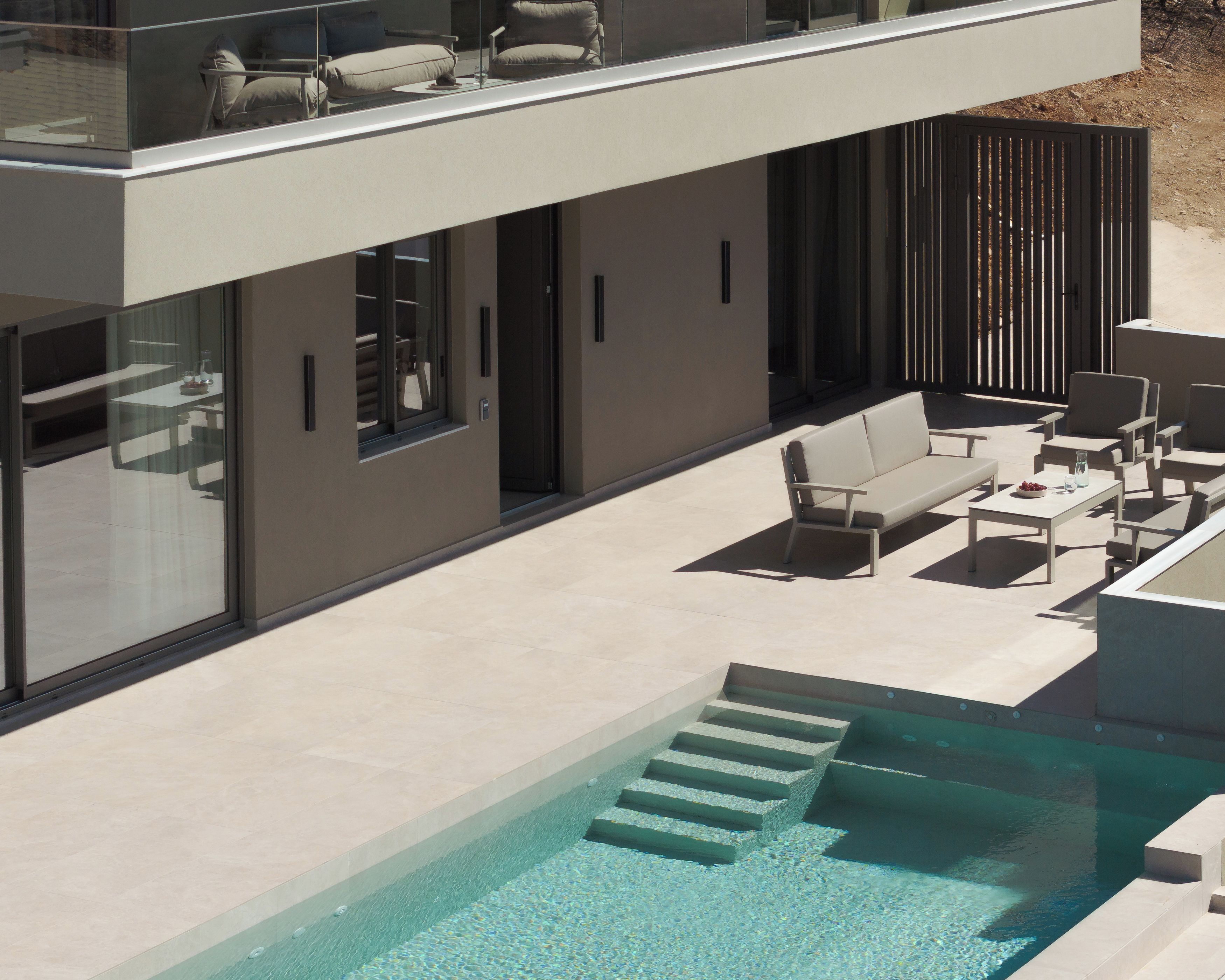 Une maison moderne à deux étages, dotée d’une piscine, d’un espace extérieur aménagé et offrant une vue sur le paysage environnant.