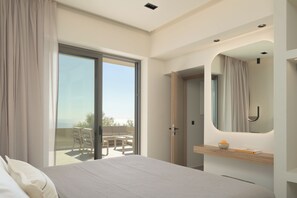 Une chambre moderne dotée d’une grande porte-fenêtre coulissante donnant sur un balcon, d’un lit recouvert d’un tissu texturé, d’une table de chevet en bois et d’un miroir à cadre incurvé.