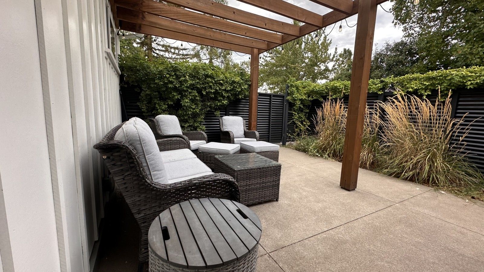 An outdoor patio with wicker furniture, including two chairs and a table.