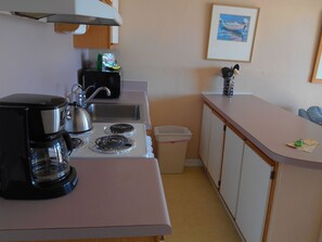 A compact kitchenette with a coffee maker, a kettle, and a sink. - A Place at the Beach (Isle of Palms)