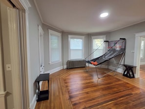 Une pièce dotée d’un plancher en bois, d’un fauteuil suspendu, d’une petite table et d’un radiateur.