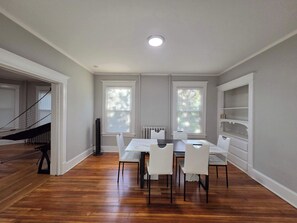 A dining area with a table and chairs, a radiator, and a staircase. - 2BR Apartment Near Wesleyan 303 (Middletown)