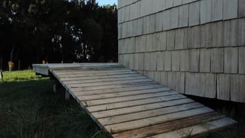 A wooden deck leading to a building with a shingled exterior.