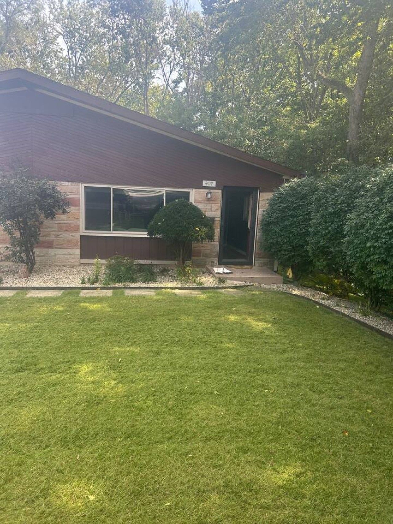 Une maison à deux étages avec une pelouse bien entretenue et une grande fenêtre.
