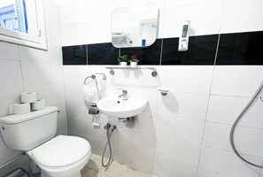 A bathroom with a toilet, sink, mirror, and towel rack. - La Marsa Vibe (Tunis)