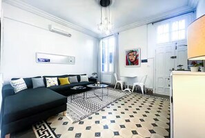 A modern living room with a black sectional sofa, a coffee table, and a patterned rug. - La Marsa Vibe (Tunis)