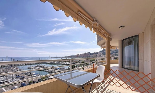 A balcony with a view of a marina and cityscape. - Air-conditioned studio, sea view terrace - 2 guests (Menton)