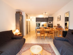A compact living space with a kitchenette, a dining area, and a sofa. - Spacious apartment at the foot of ski slopes - 8 guests (Villarodin-Bourget)