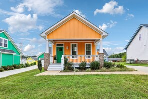 A single-story house with a front porch, a green door, and a white railing. - Iconic Winchester home near Tims Ford State Park! (Winchester)