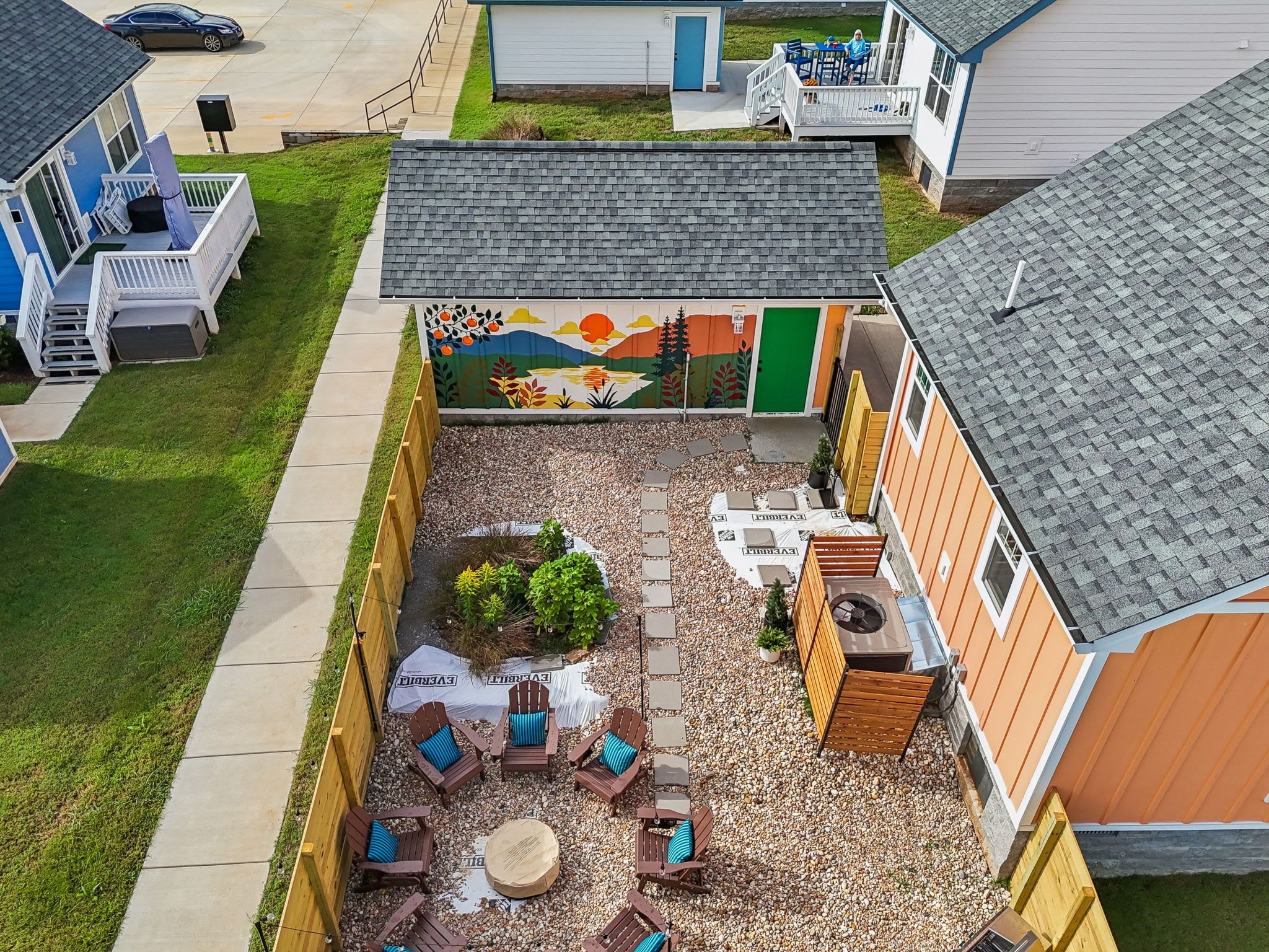 A residential area with a patio, outdoor seating, and a mural.