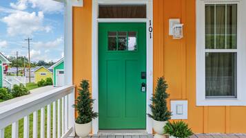 A house with a green door, a white porch railing, and a small window.