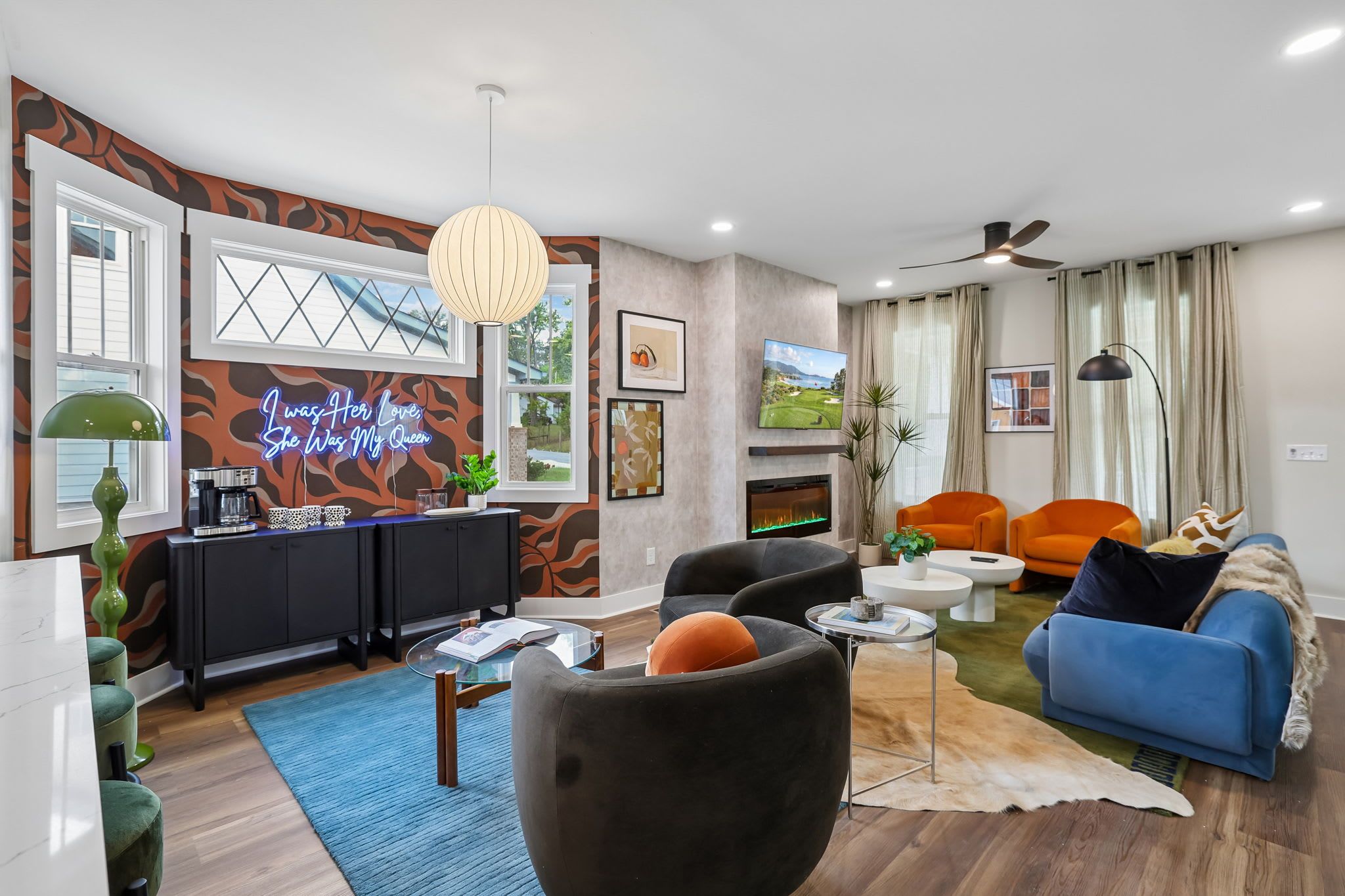 A modern living room with a fireplace, a television, and a blue sofa.