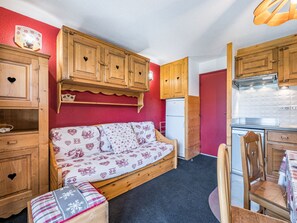 A compact kitchen with wooden cabinets and a built-in refrigerator. - Cozy apartment near slopes - 4 guests (Les Menuires)