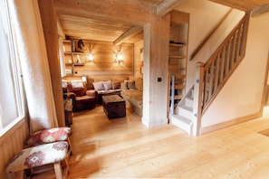 A wooden interior with a staircase, a sofa, and a coffee table. - Roche des Fours 210 (Val-d'Isère)