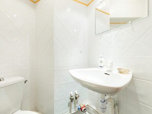 Ein Badezimmer mit Waschbecken, Spiegel und Toilette.