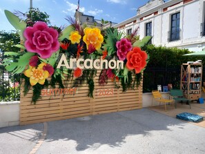 A wooden wall with the text 'Arcachon' and 'Summer 2023' indicating a summer event or location.