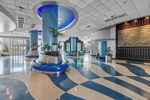 A spacious lobby with a checkered floor, large blue pillars, and a decorative wall mural. - ☀️Ocean Front Condo with Expansive Views-Daytona Ocean Walk Resort 2023 A/B☀️ (Daytona Beach)