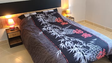 Un dormitorio con cama, mesitas de noche y lámparas.