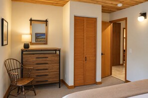 A room with a wooden dresser, a chair, a wardrobe, and a bed. - Black Butte Ranch Aspen House 021 (Sisters)