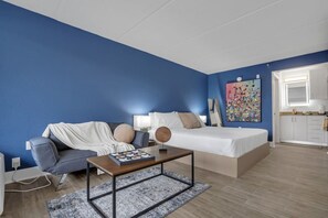 A modern bedroom with a bed, a sofa, a coffee table, and a painting on the wall. - Disney Magic 7 Min Away + Free Parking and Pool (Kissimmee)