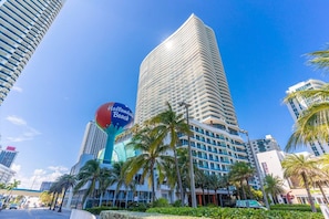 A high-rise hotel with a distinctive curved facade, a prominent beach-themed sign, and palm trees in the foreground. - Luxury High-Rise Apartment with Stunning Views (Hollywood)