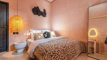 Une chambre moderne avec un grand lit, une table de chevet, une lampe fixée au mur et un miroir.