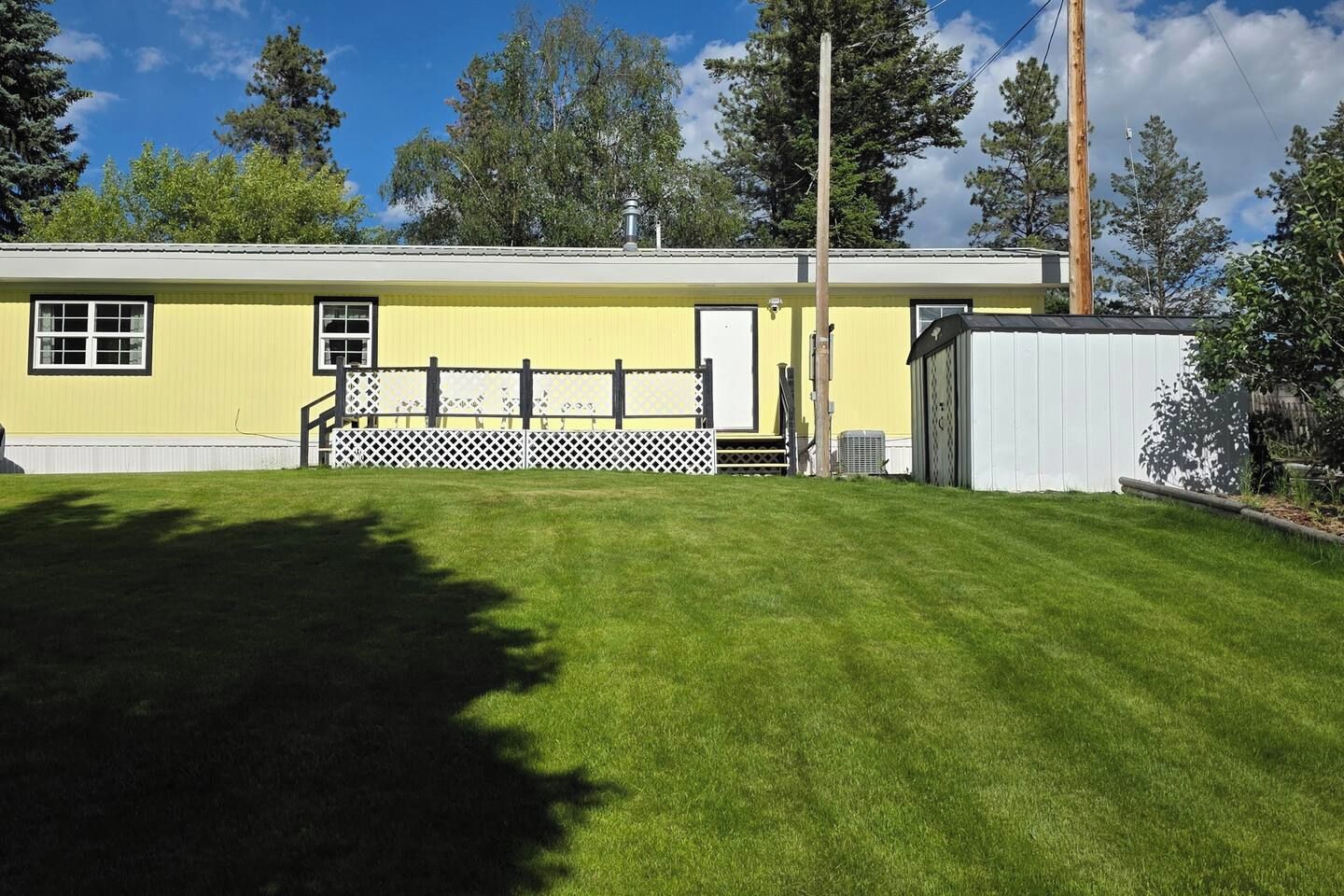 A yellow building with a fenced yard and a white garage.