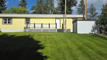 A yellow building with a fenced yard and a white garage.