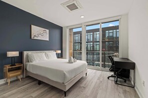 A modern bedroom with a bed, bedside tables, a desk, and a large window. - Urban 1BR Escape | Northern Liberties (Philadelphia)