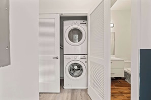 A laundry room with two stacked washing machines and a shower area. - Urban 1BR Escape | Northern Liberties (Philadelphia)