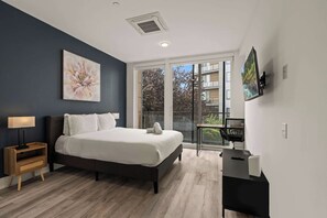 A modern bedroom with a large bed, a nightstand, a desk, and a TV. - Modern 1BR | Sleeps 2 | Near Fishtown (Philadelphia)