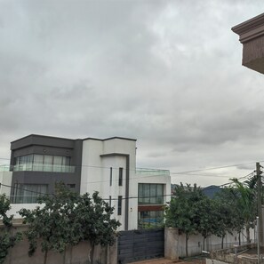 A modern two-story building with a flat roof and large windows. - 3 Bedroom Gorgeous Home, Gated with Security Cams & Mountain Views! (Oyarifa)