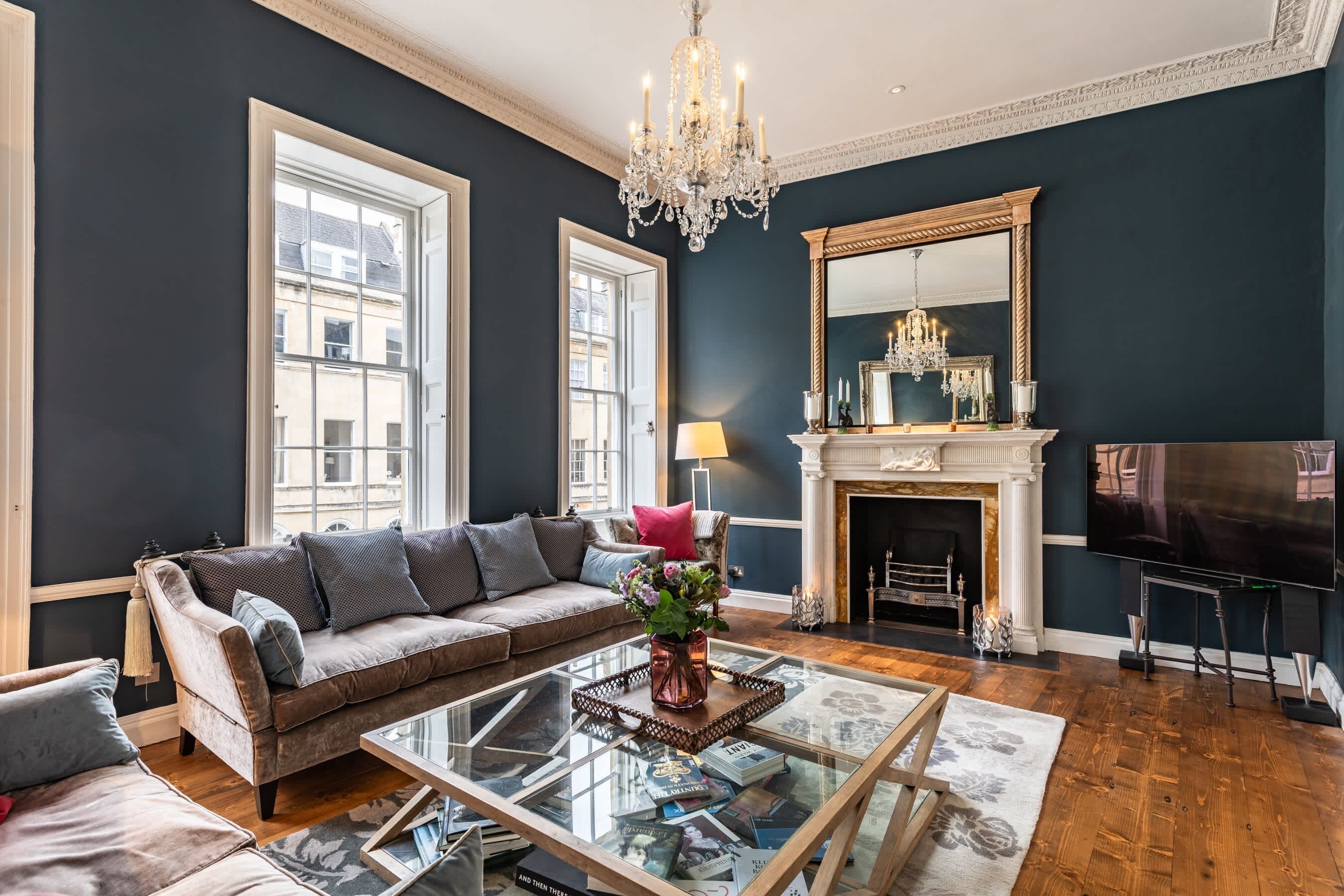A living room with a sofa, a glass coffee table, a fireplace, and a television.