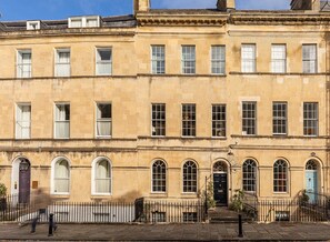 A row of terraced houses with uniform windows and arched doorways. - Central Townhouse With Walled Garden Parking (Bath)