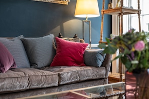 A leather sofa with patterned cushions, a floor lamp, and a vase with flowers. - Central Townhouse With Walled Garden Parking (Bath)