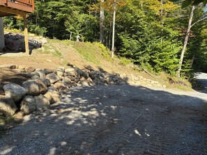Ein Kiesweg, an einer Seite eine Steinmauer und an der anderen eine Holzkonstruktion.