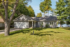 Ein eingeschossiges Haus mit Garage, überdachter Veranda und kleinem Vorgarten.