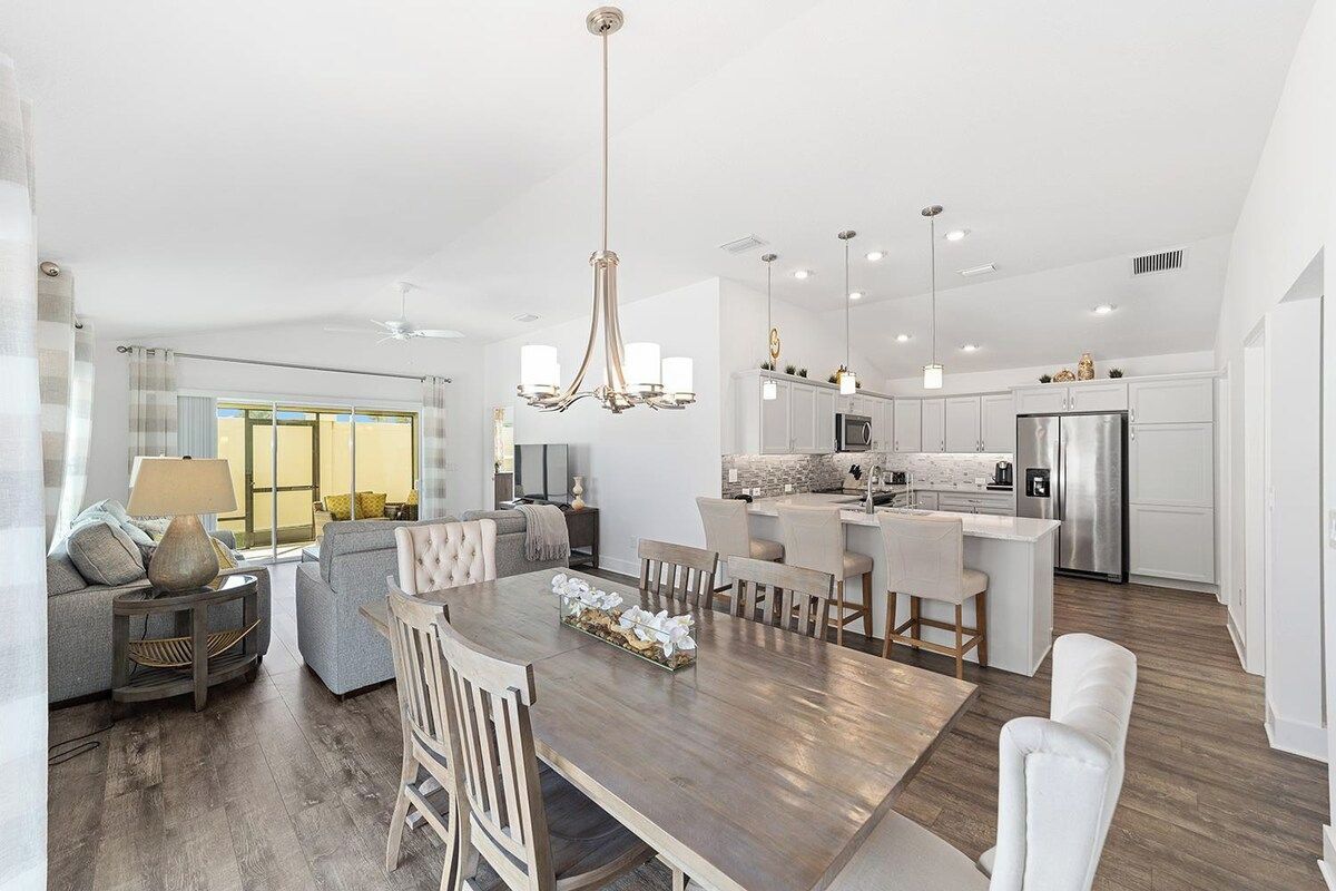 A modern kitchen with white cabinets, stainless steel appliances, and a central island.