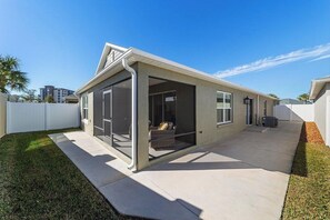 A modern single-story house with a covered patio, a garage, and a fenced backyard. - The Big Cat 3BR | Lanai | Near Brownwood (The Villages)