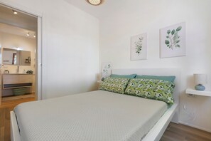 A bedroom with a bed, a nightstand, a lamp, and two wall-mounted pictures. - Apartment 'Salsedine's House' with Private Garden, Wi-Fi and Air Conditioning (Arboriamar)