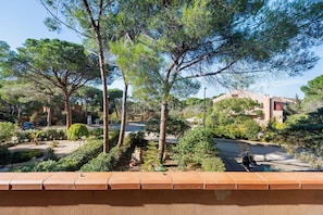 A residential area with a paved road, trees, and a building with a red door. - Apartment 'Salsedine's House' with Private Garden, Wi-Fi and Air Conditioning (Arboriamar)