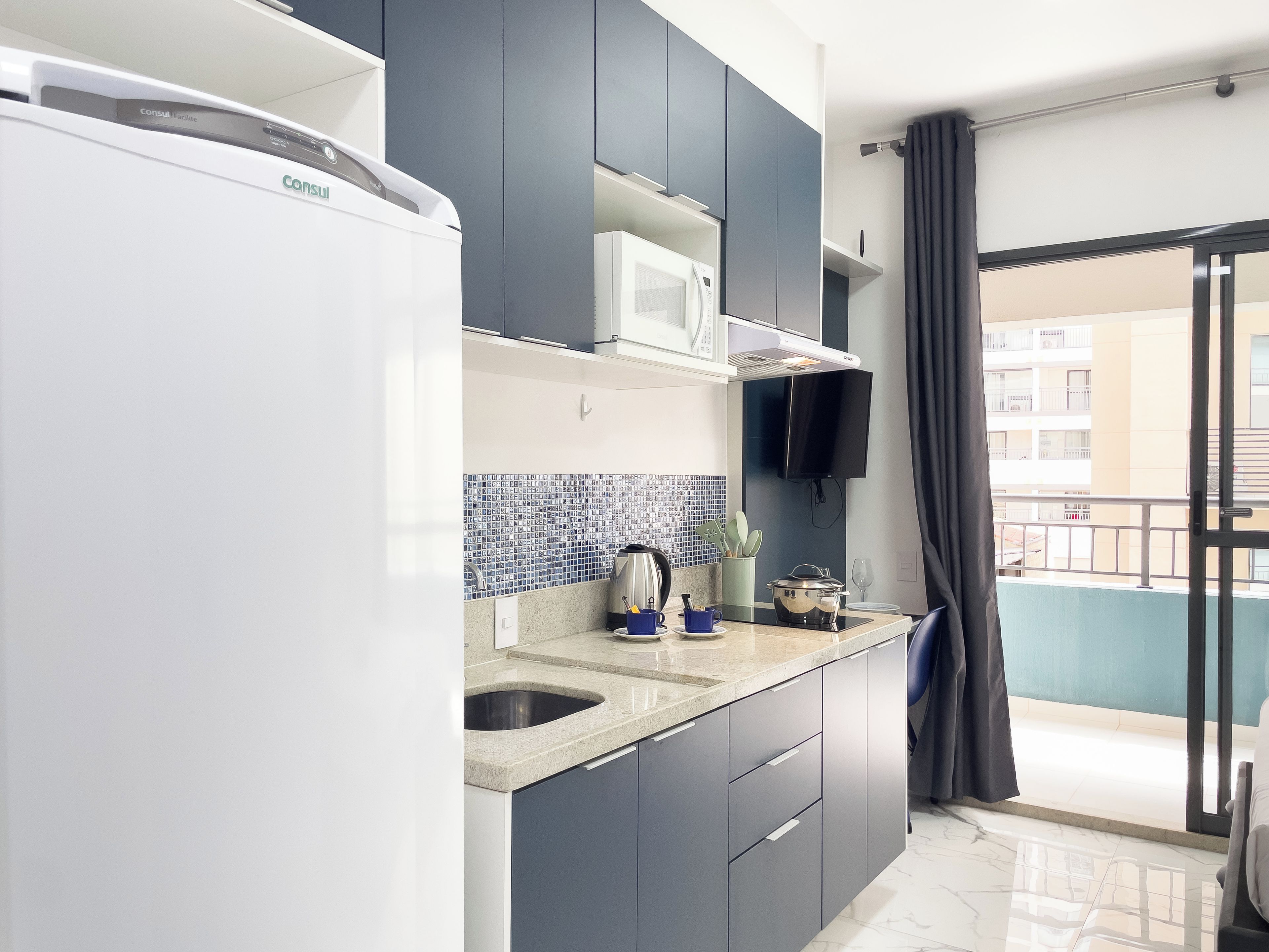 A modern kitchen with a built-in microwave, a sink, and a stove.