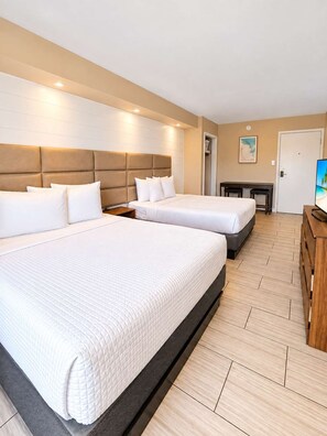 A hotel room with two beds, a wooden desk, and a television. - Tidal Bliss at 300 Tenth | 225 (Myrtle Beach)