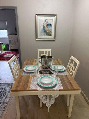 A dining table set with plates, a candle holder, and a framed artwork on the wall. - Luxurious Beach Front Villa Pool-Gym-AC Sleeps 5! (Turtle Bay)